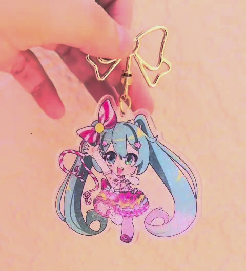 Miku keychain being held by the clasp, turning slowly to the right, showing of the holographic finish